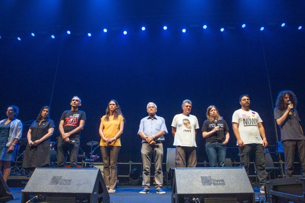 Event presenters stand on the stage