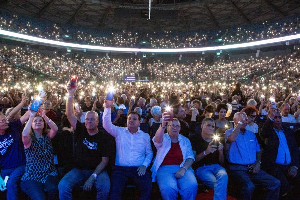 Event participants shine the lights from their phones