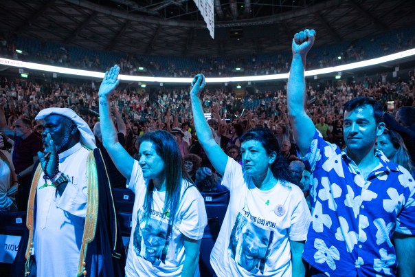 Attendees at the rally raise their hands